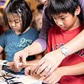 children and teacher doing hands-on STEM activity